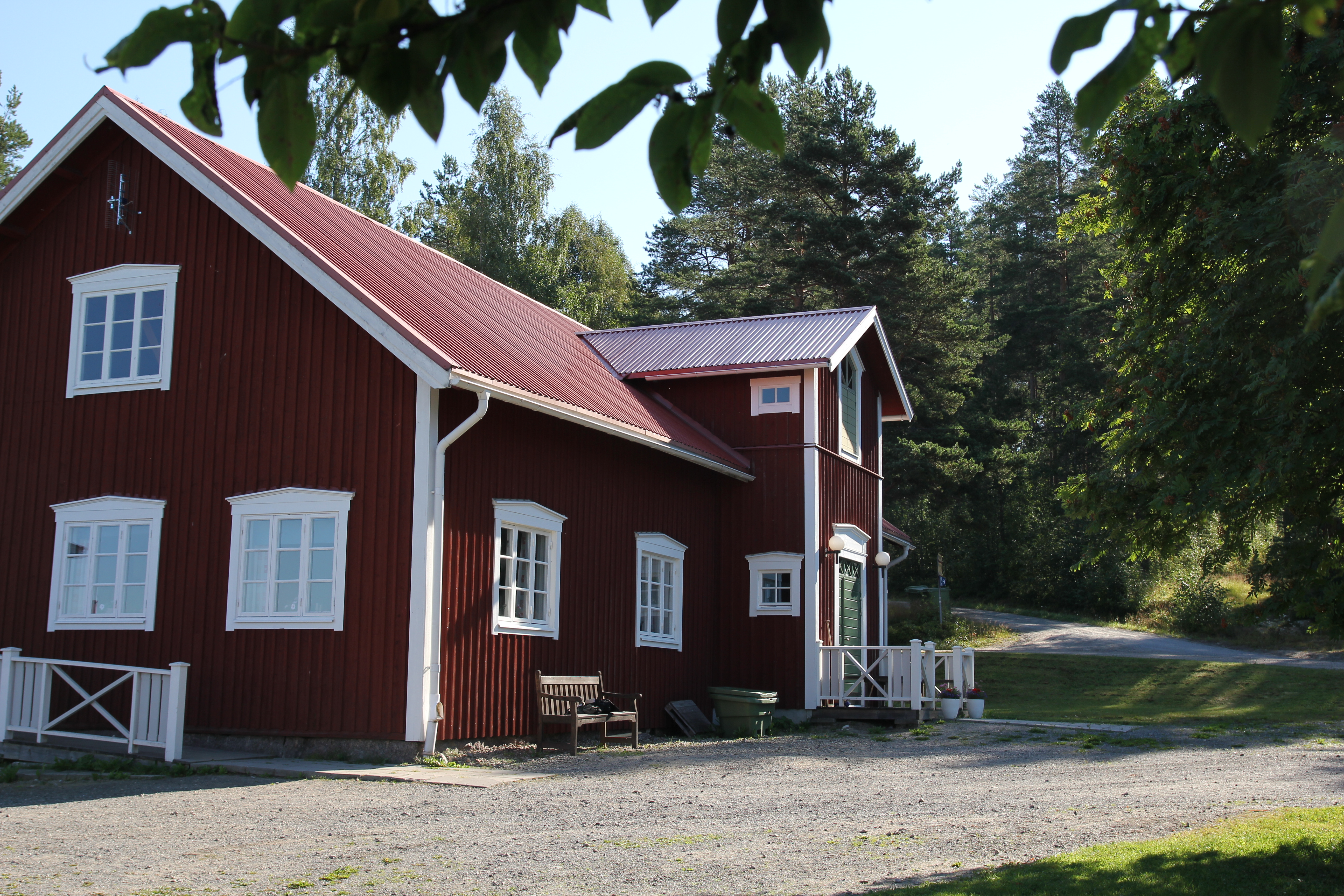 Lägergårdens huvudbyggnad med kök, matsal, samlingssal med öppen spis och en veranda med utsikt mot sjön.