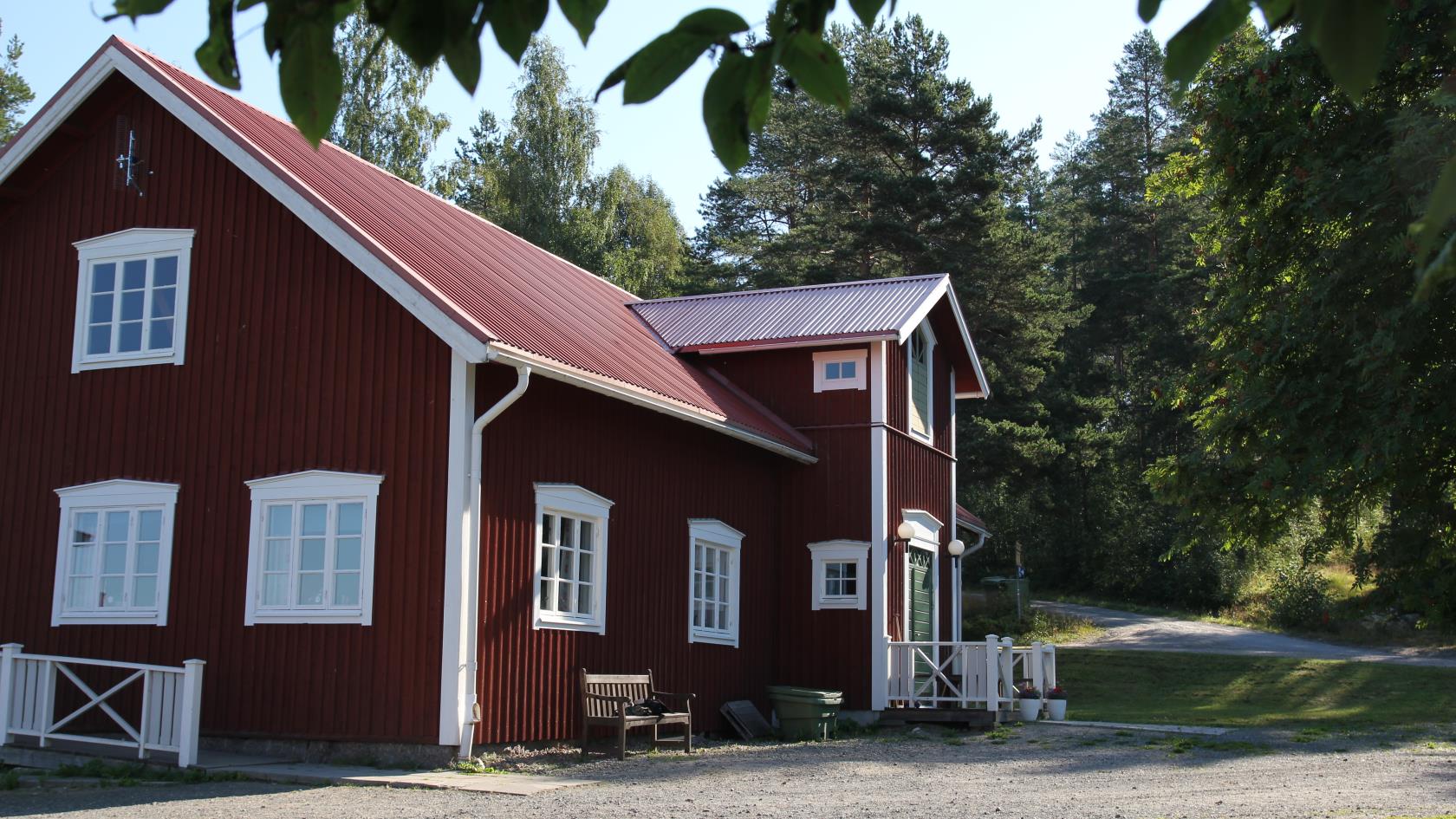 Lägergårdens huvudbyggnad med kök, matsal, samlingssal med öppen spis och en veranda med utsikt mot sjön.