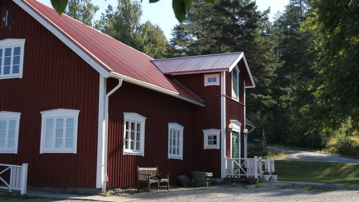 Lägergårdens huvudbyggnad med kök, matsal, samlingssal med öppen spis och en veranda med utsikt mot sjön.