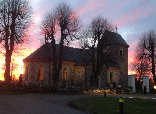 Vallentuna kyrka, det är vår och solen är på väg att gå ner.