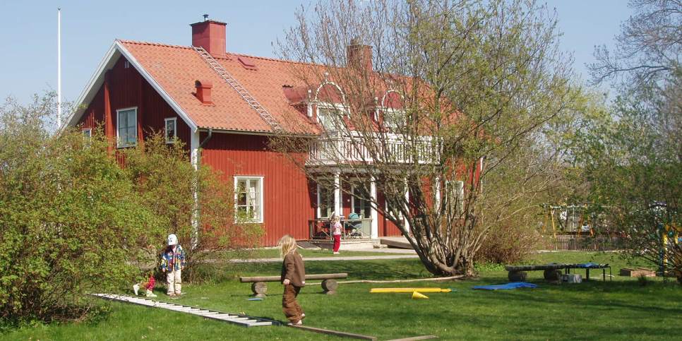 Prästgården, det är vår, några barn leker i gräset