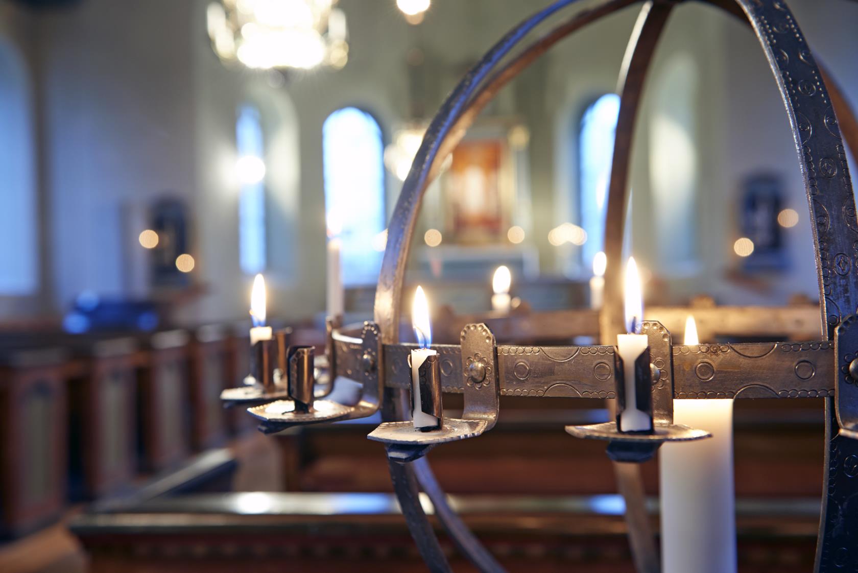Ljusbärare med tända ljus i Malexanders kyrka.