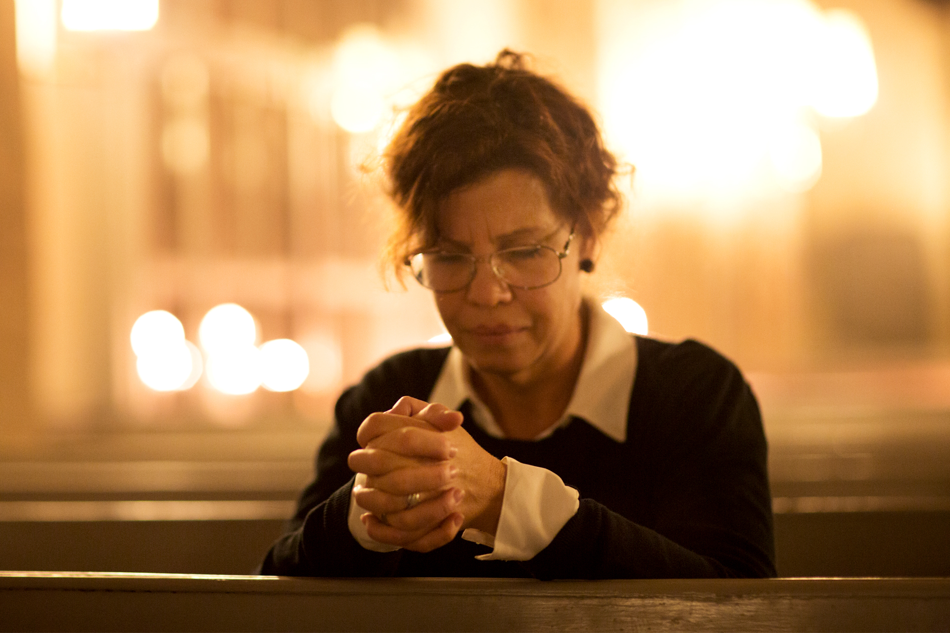 Bön, kvinna bedjer i kyrksalen