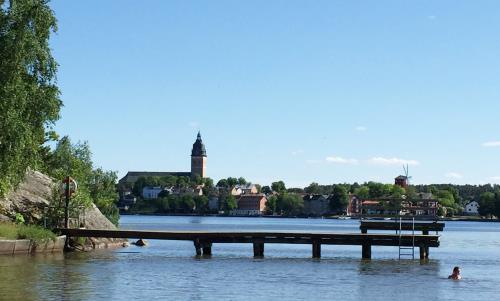 En brygga i vattnet och längre bort syns Strängnäs.