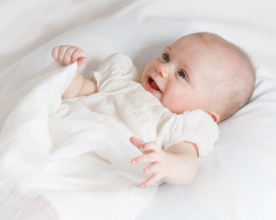 Ett litet barn i dopklänning.