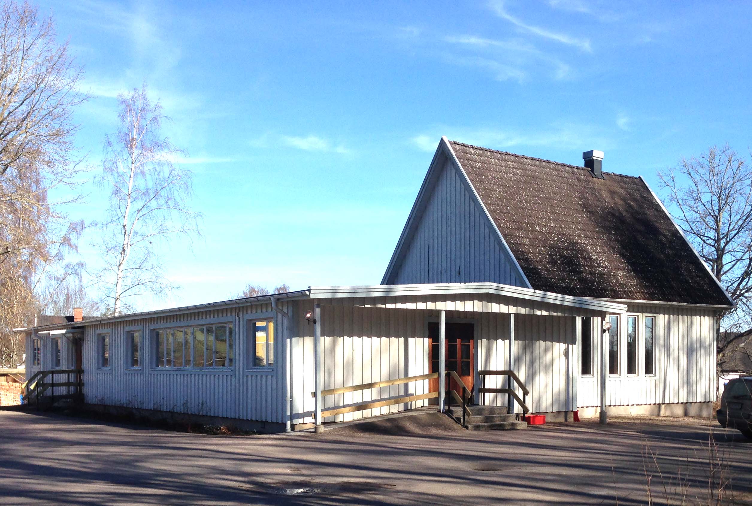 Ekedalens församlingsgård i solsken, himlen är blå.