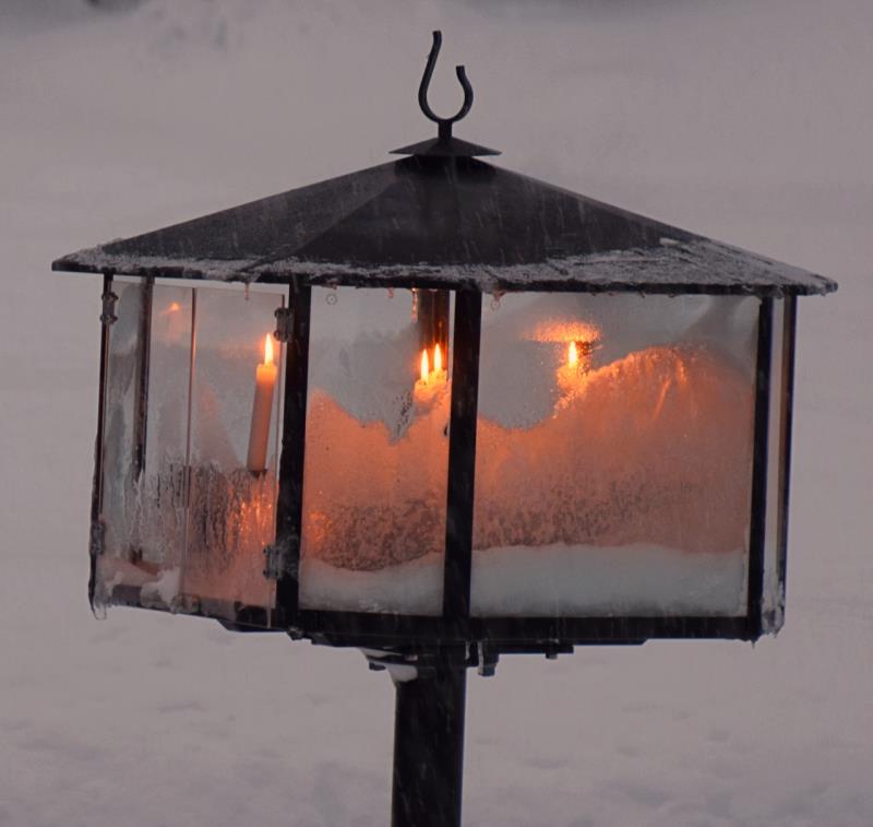 Ljusbäraren med frostiga glasrutor och ljus som brinner utanför Högvålens kapell.
