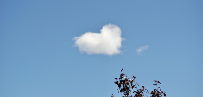 Ett moln har formen av ett hjärta på den blå himlen.