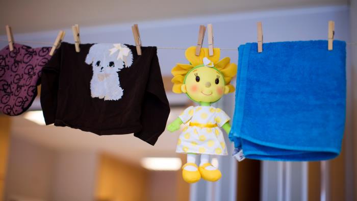 Kläder, en docka och en handduk hänger på en tvättlina.
