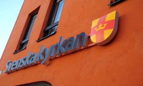 Svenska kyrkans logotyp på Kyrkans hus i Uppsala.