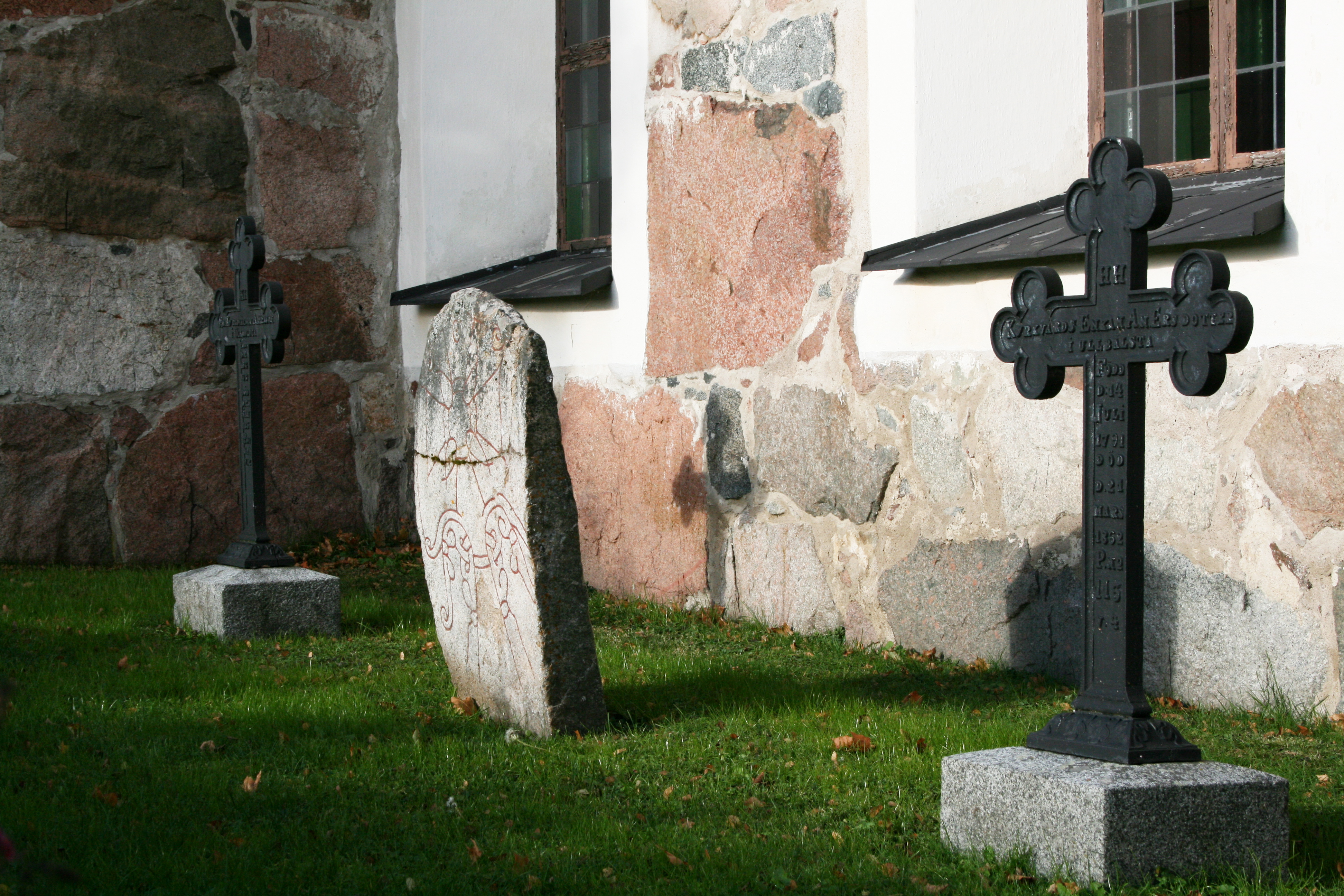 Tre gravstenar utanför en kyrka.