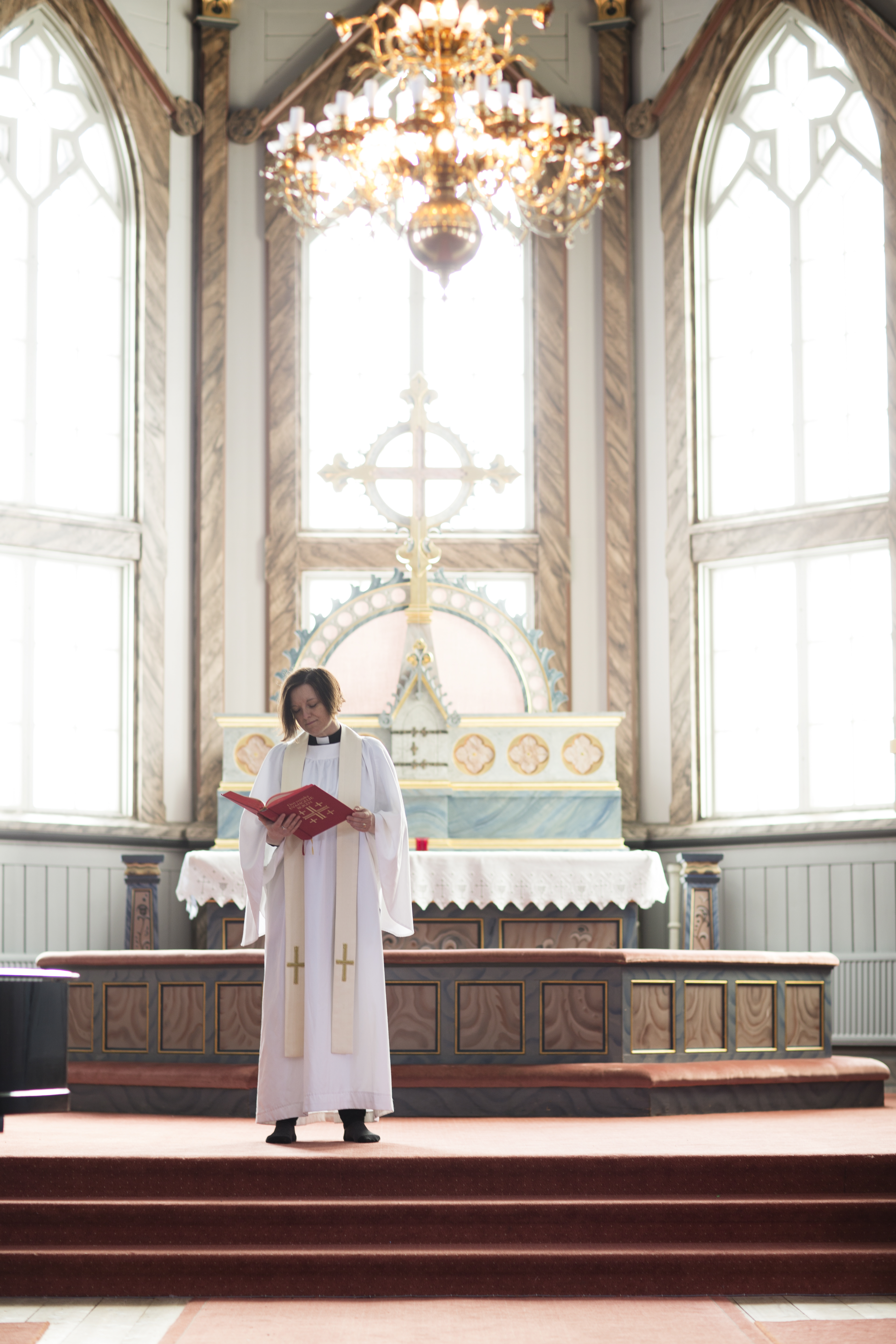 En kvinnlig präst står framme i koret.