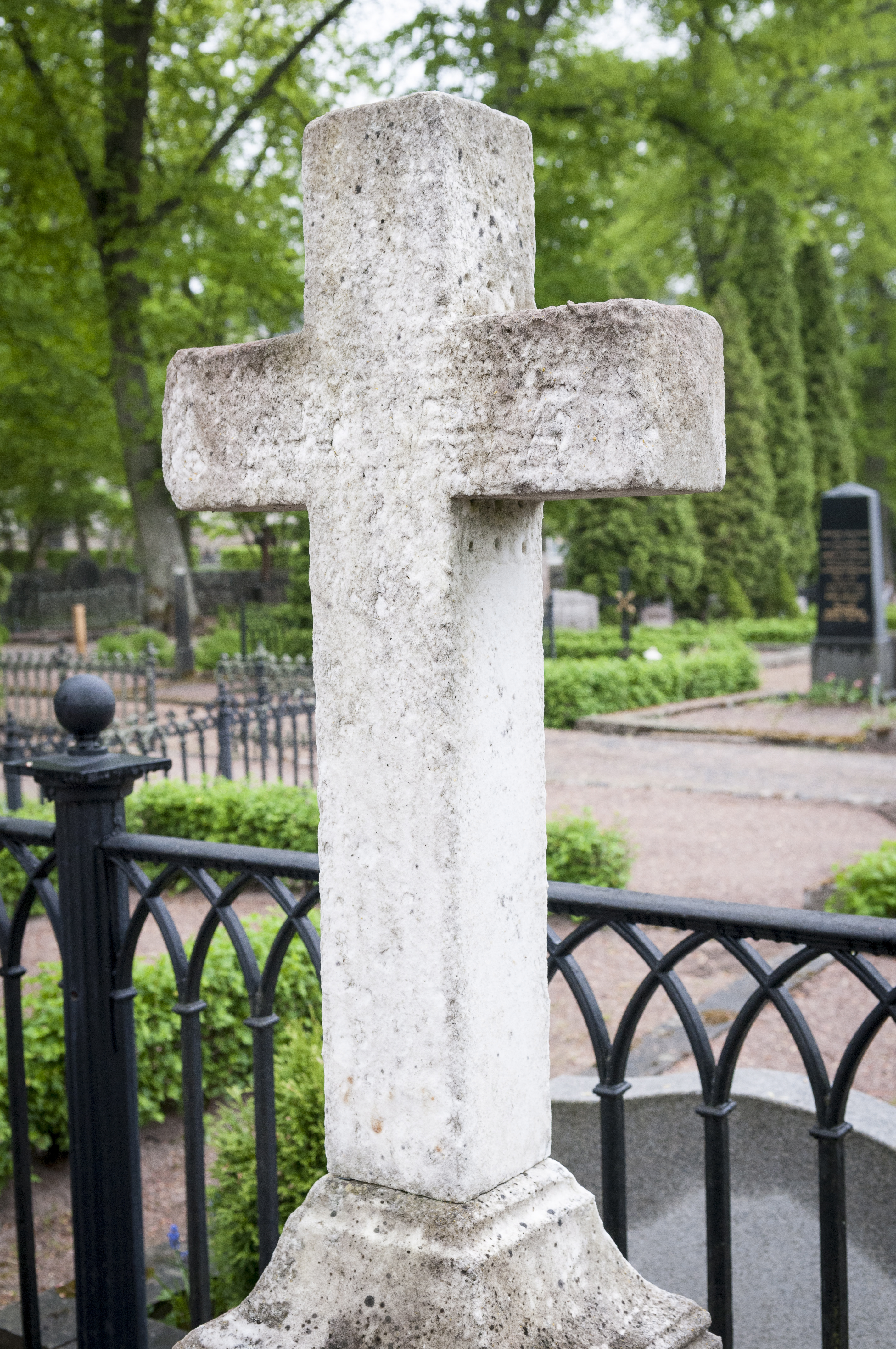 En gravsten i form av ett kors på en kyrkogård.