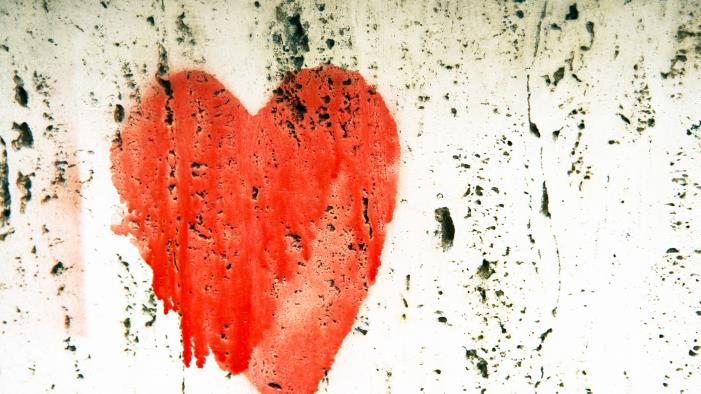 Ett målat rött hjärta på en vit vägg.