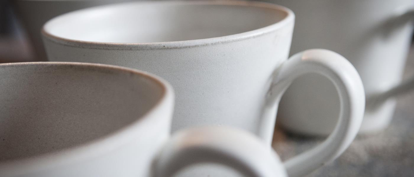 Några vita kaffemuggar i keramik.