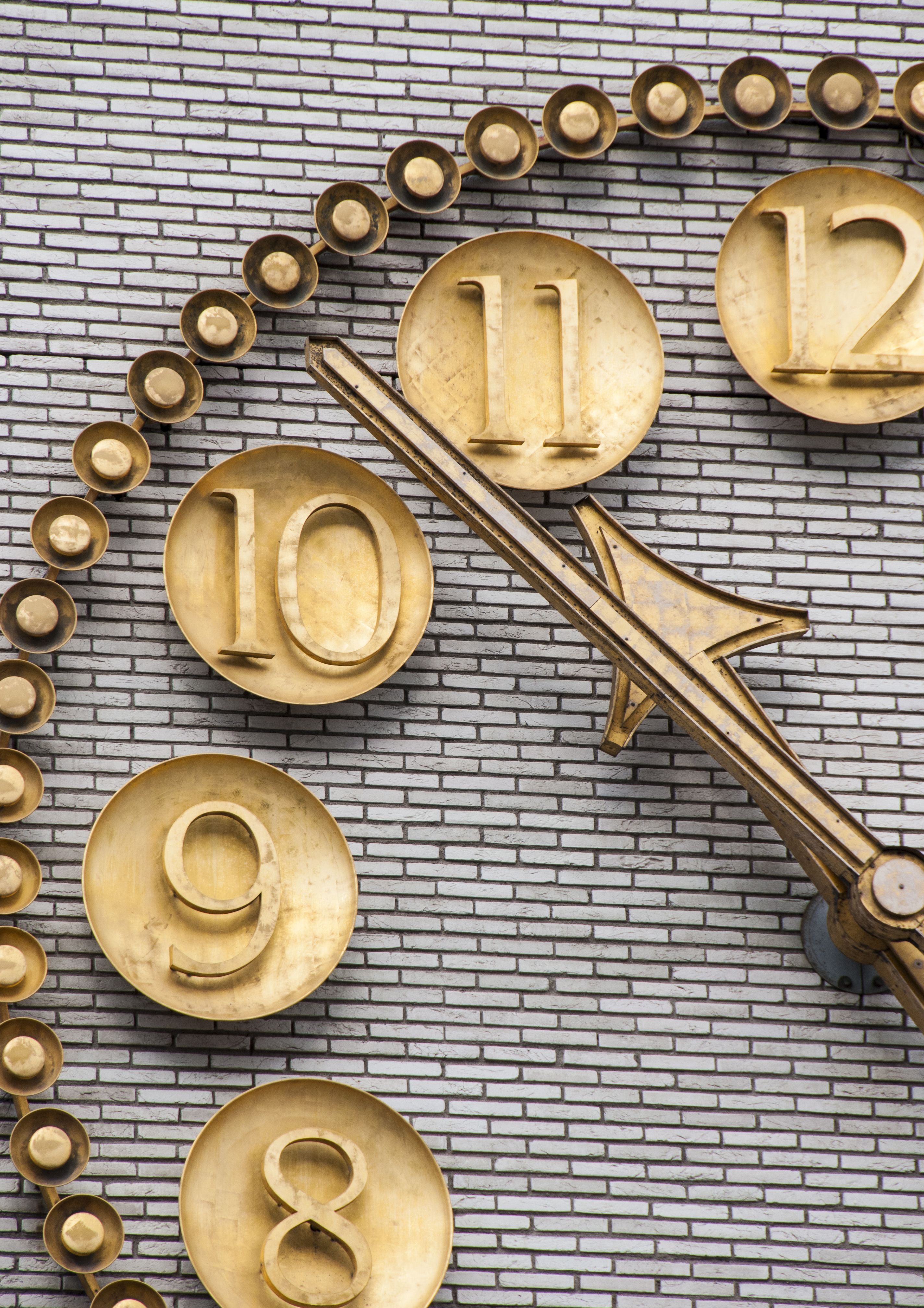 En stor guldig urtavla på en tegelvägg.