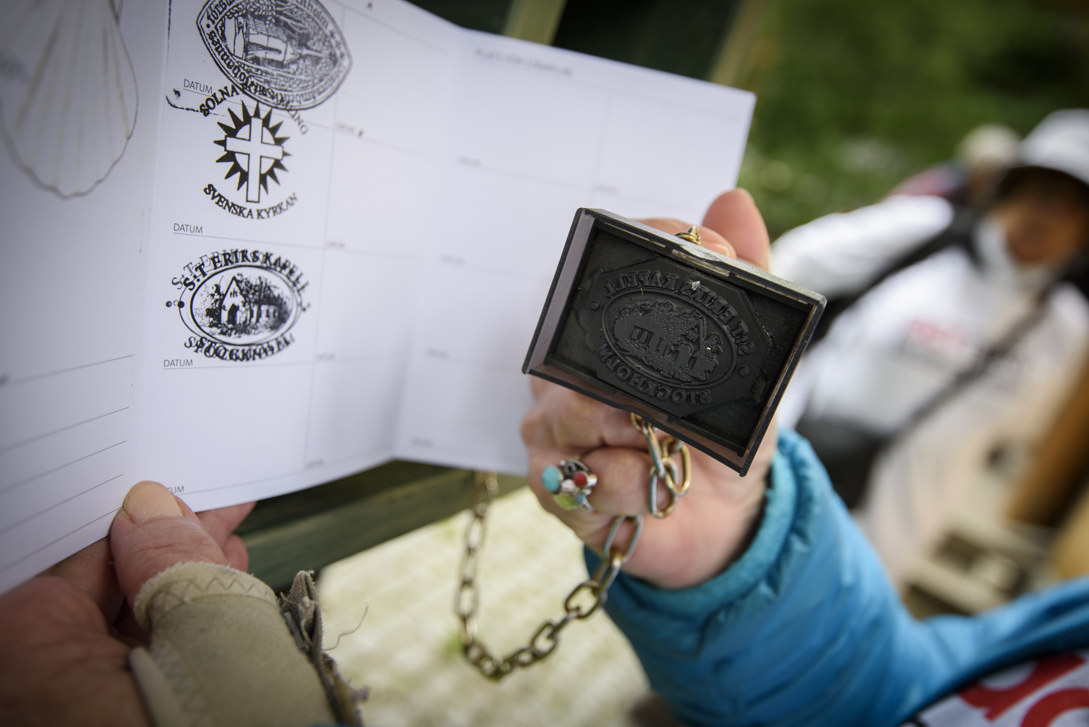 Någon håller upp en stämpel och ett stämpelkort mot kameran.