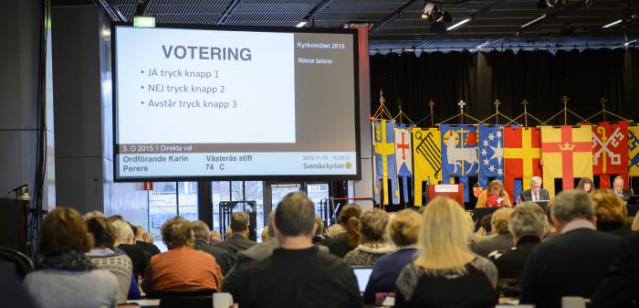 Bild från kyrkomötet. På duken längst fram visas texten Votering.
