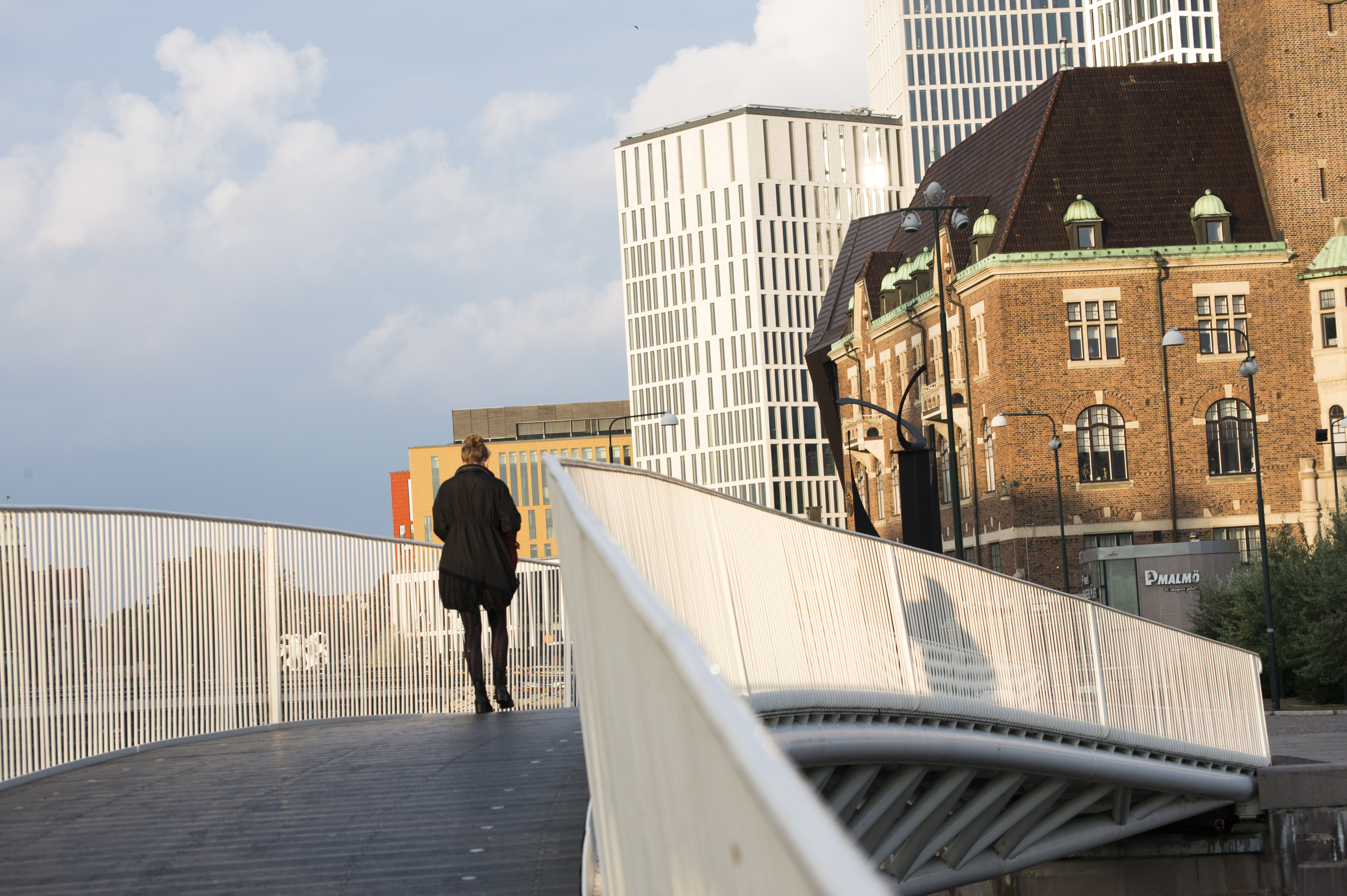 Någon går över en bro i stadsmiljö.