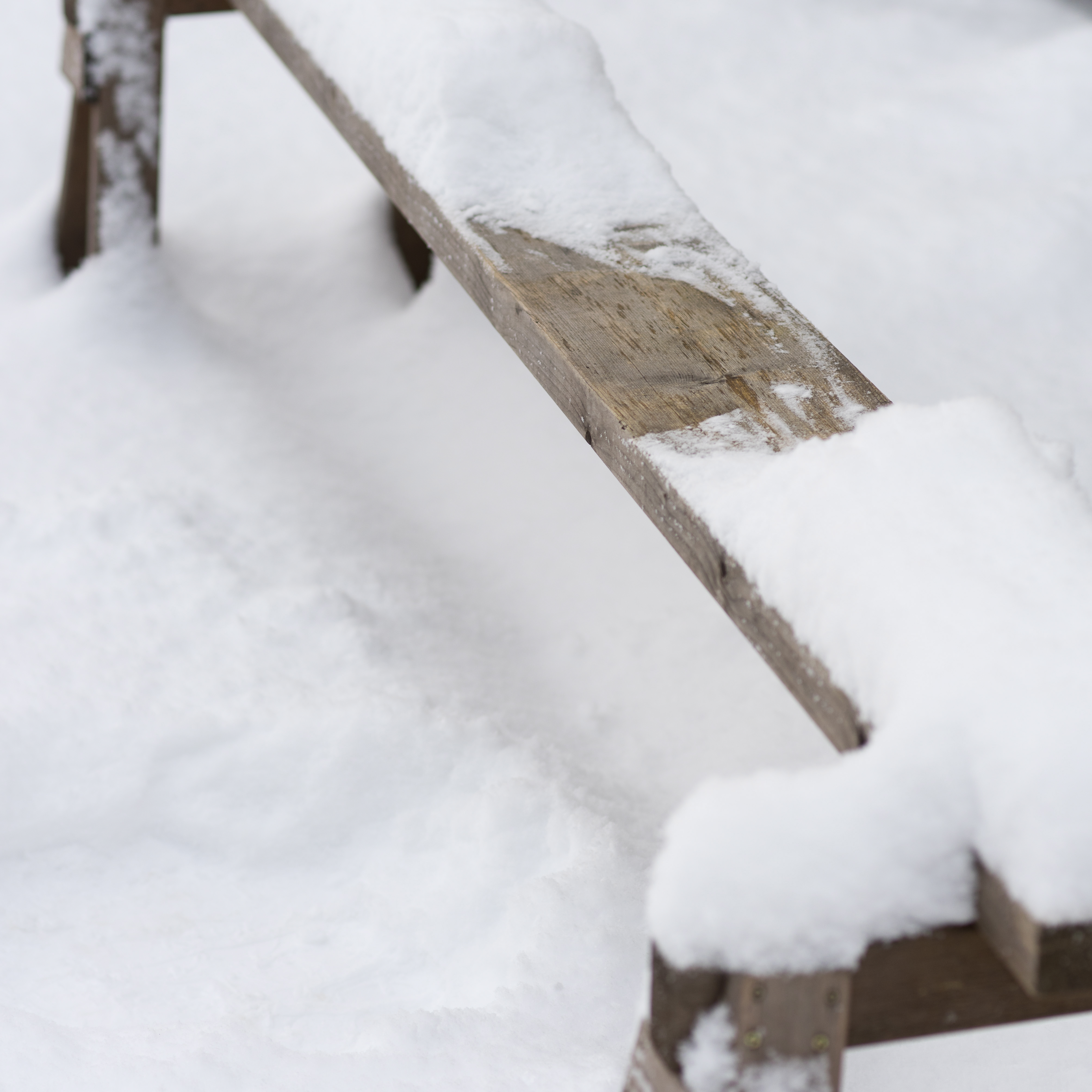 Ett sittavtryck på en snötäckt bänk.