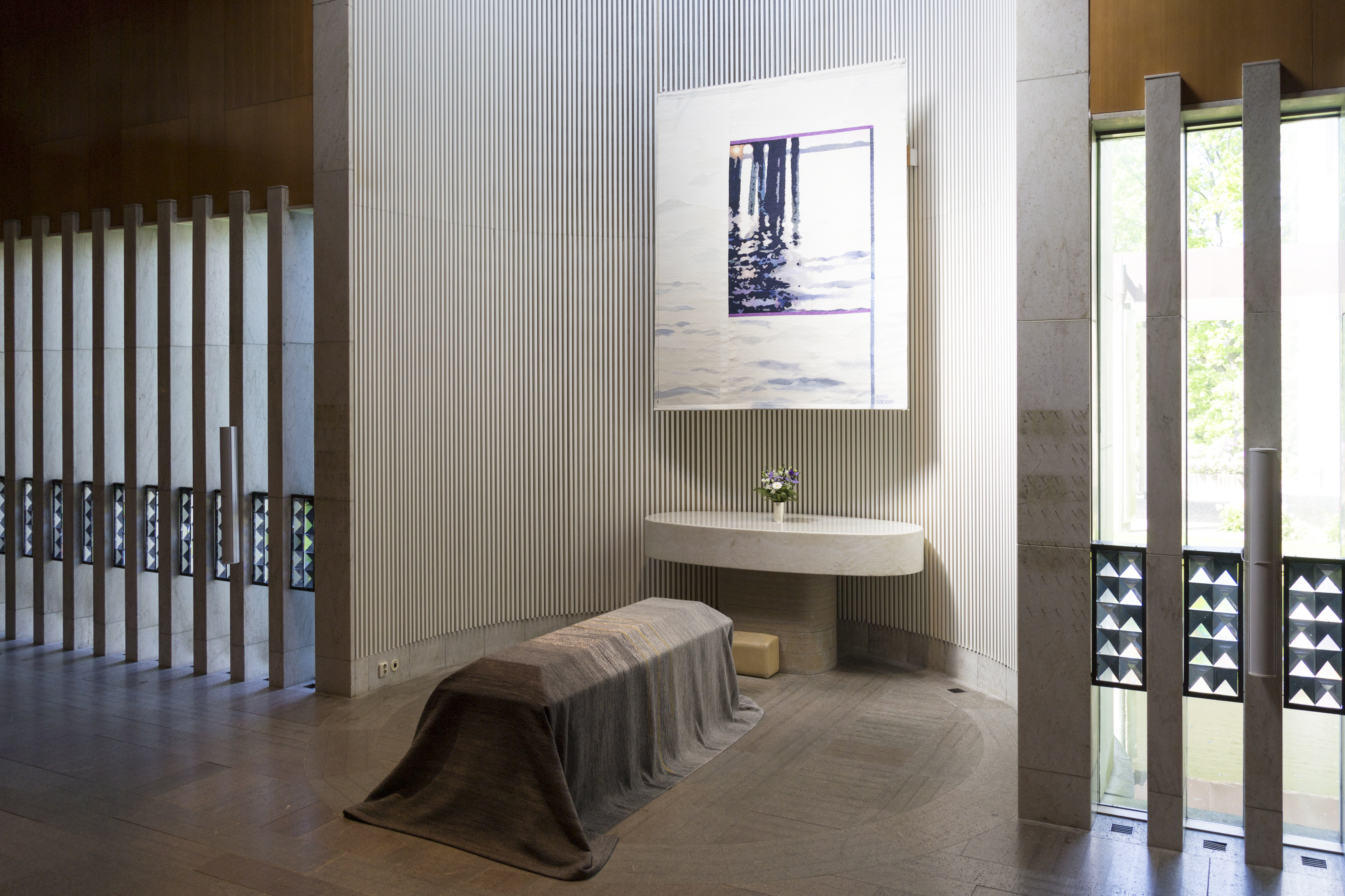 Ett skynke ligger över en kista framför ett altare.