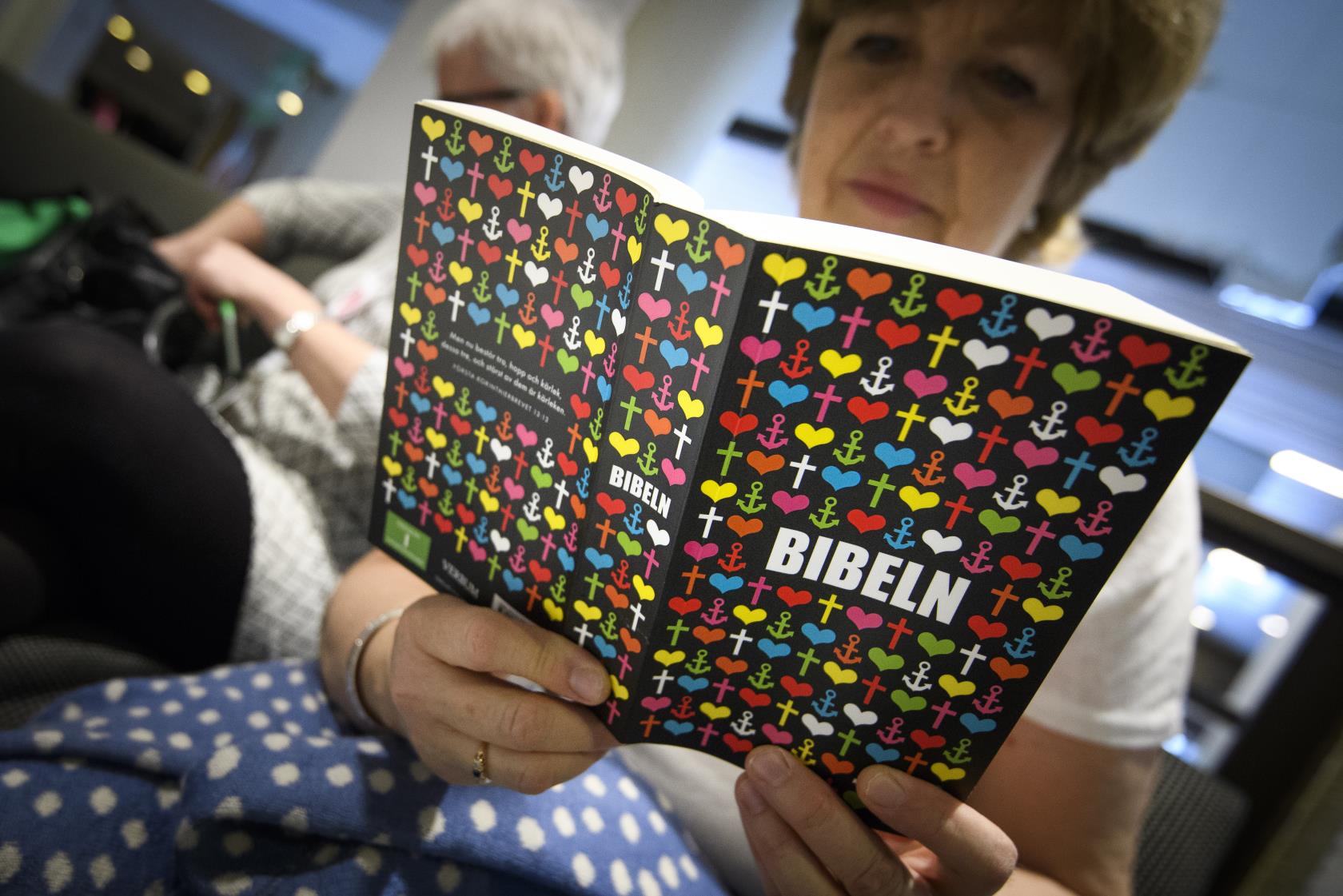 En äldre kvinna läser en bibel.