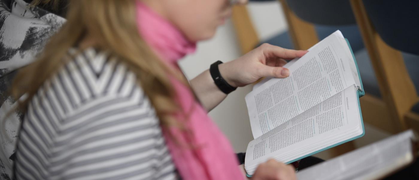 Två personer sitter bredvid varandra och läser varsin bibel.