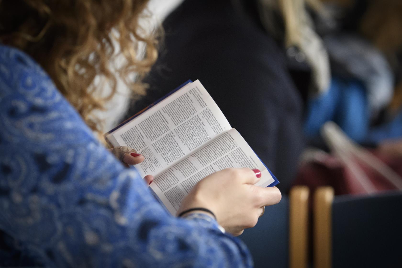 En kvinna läser ur Bibeln.