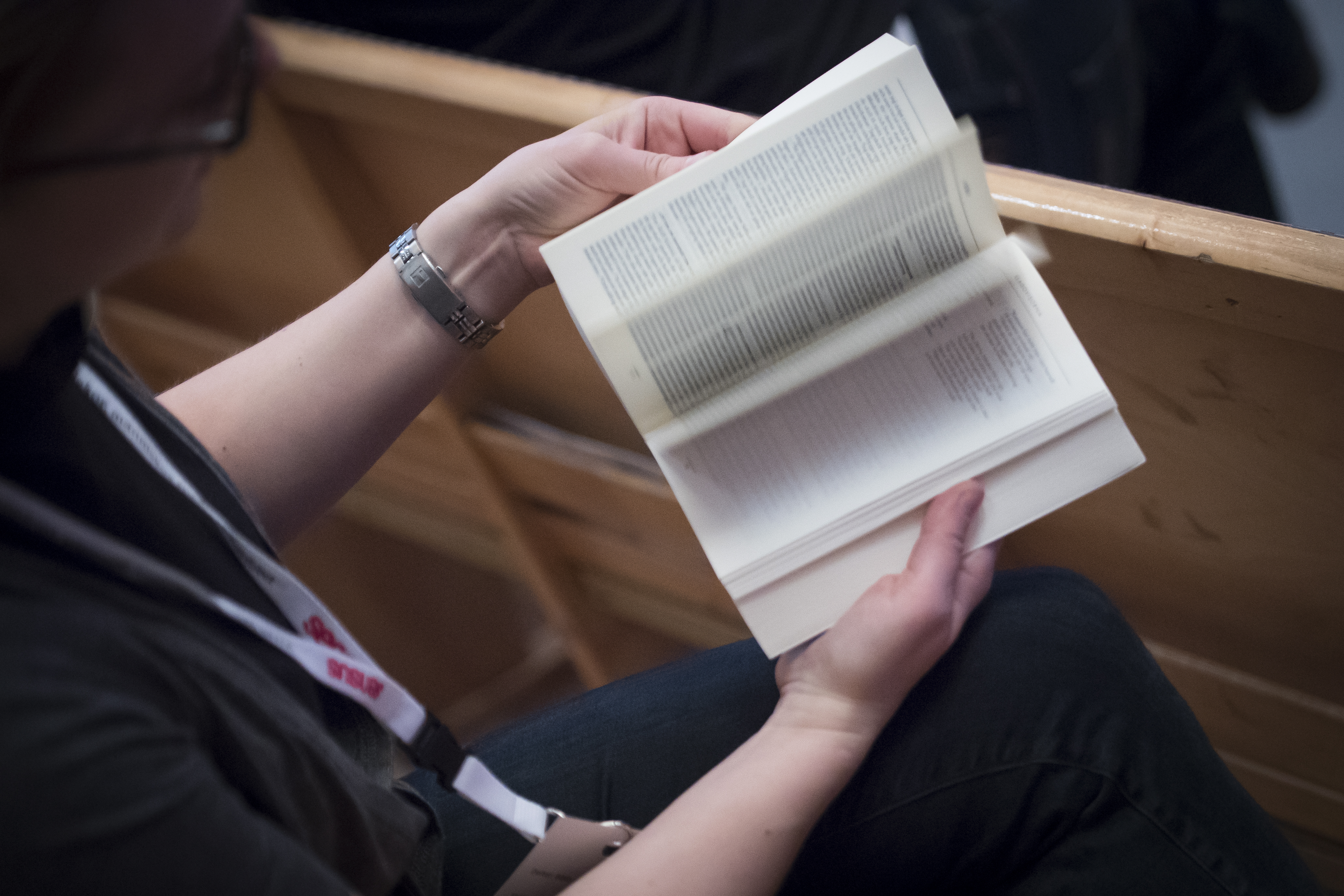 En person sitter och bläddrar i en bibel.