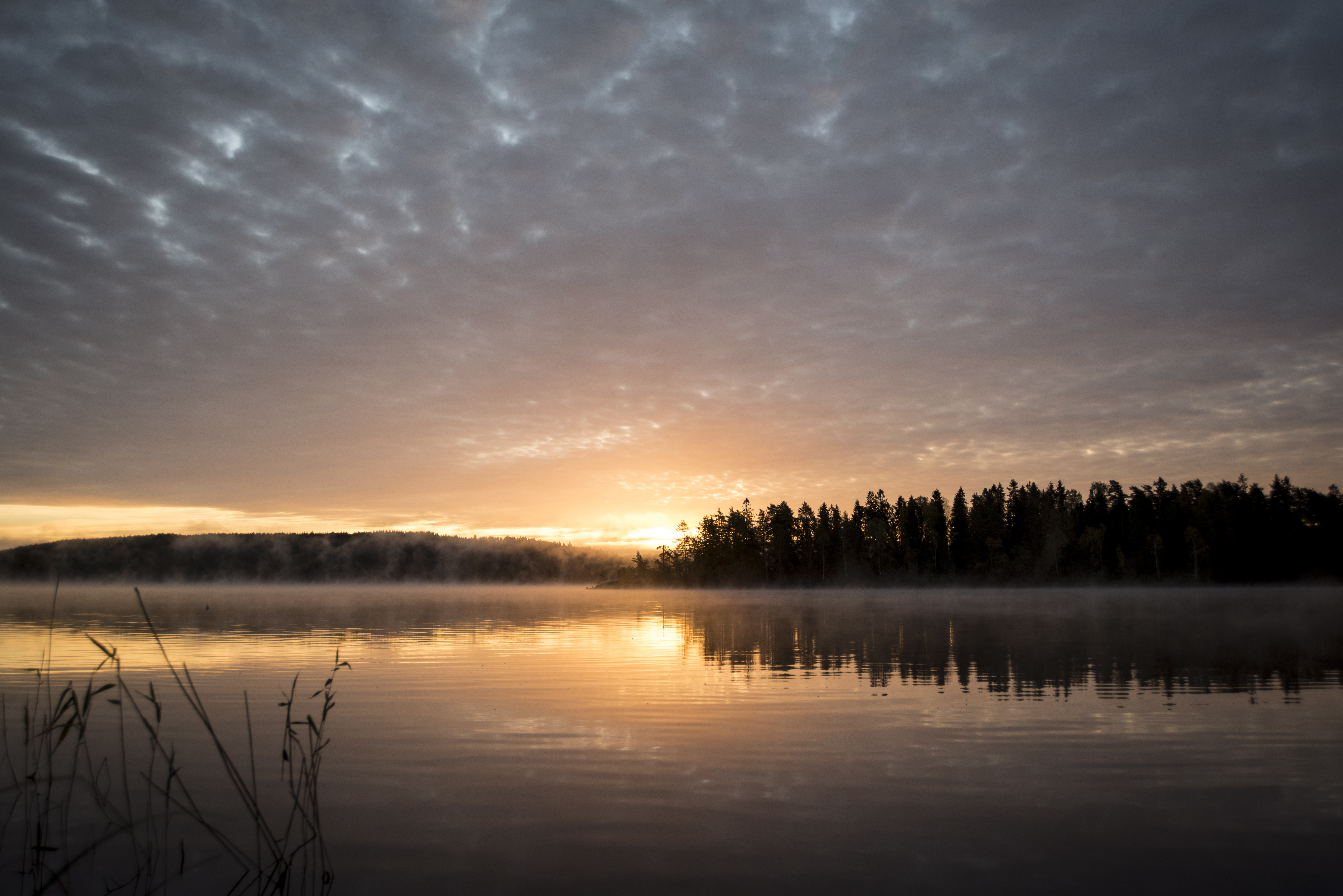 Solnedgång vid en stilla sjö.