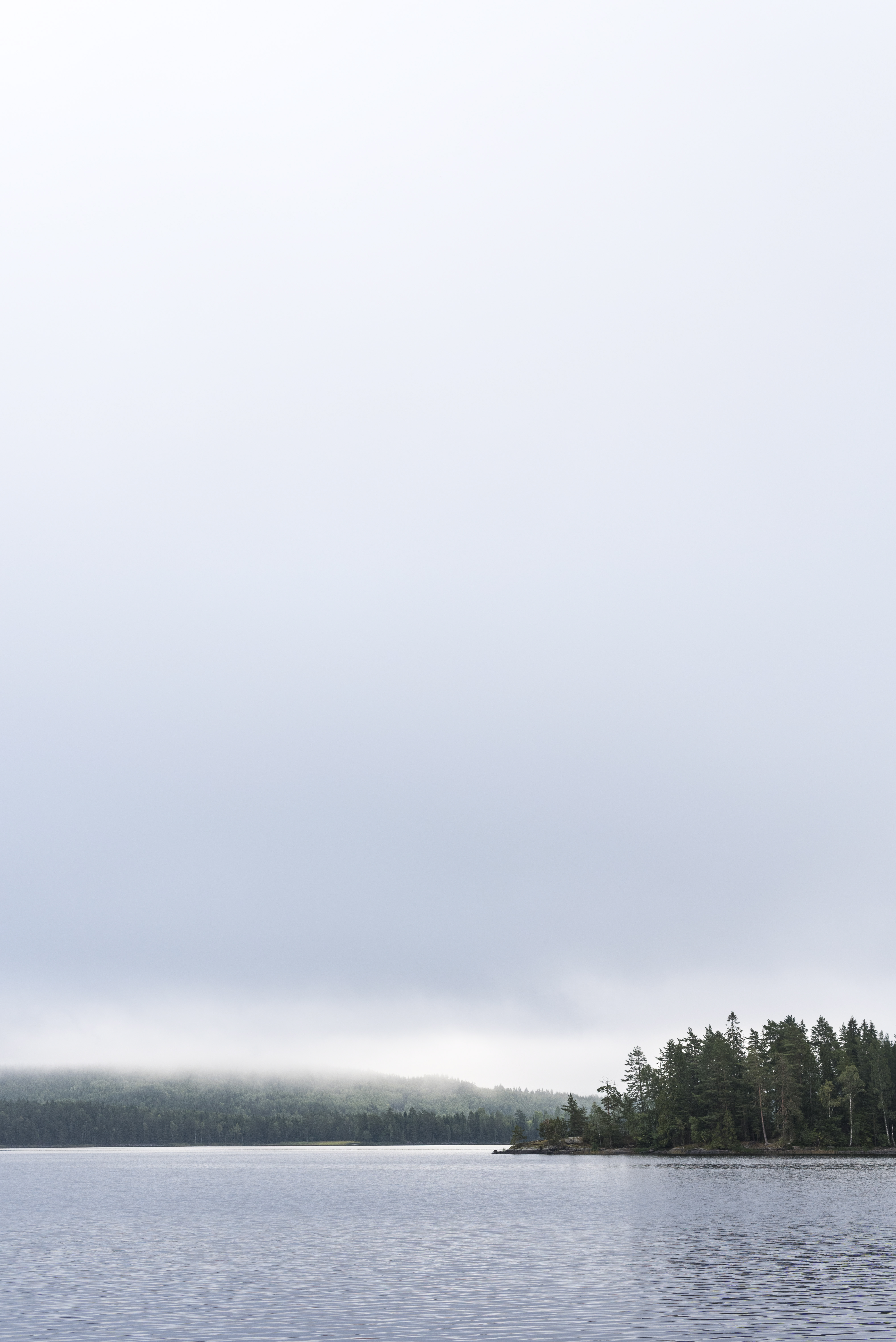 Gråa moln som drar in över en sjö.