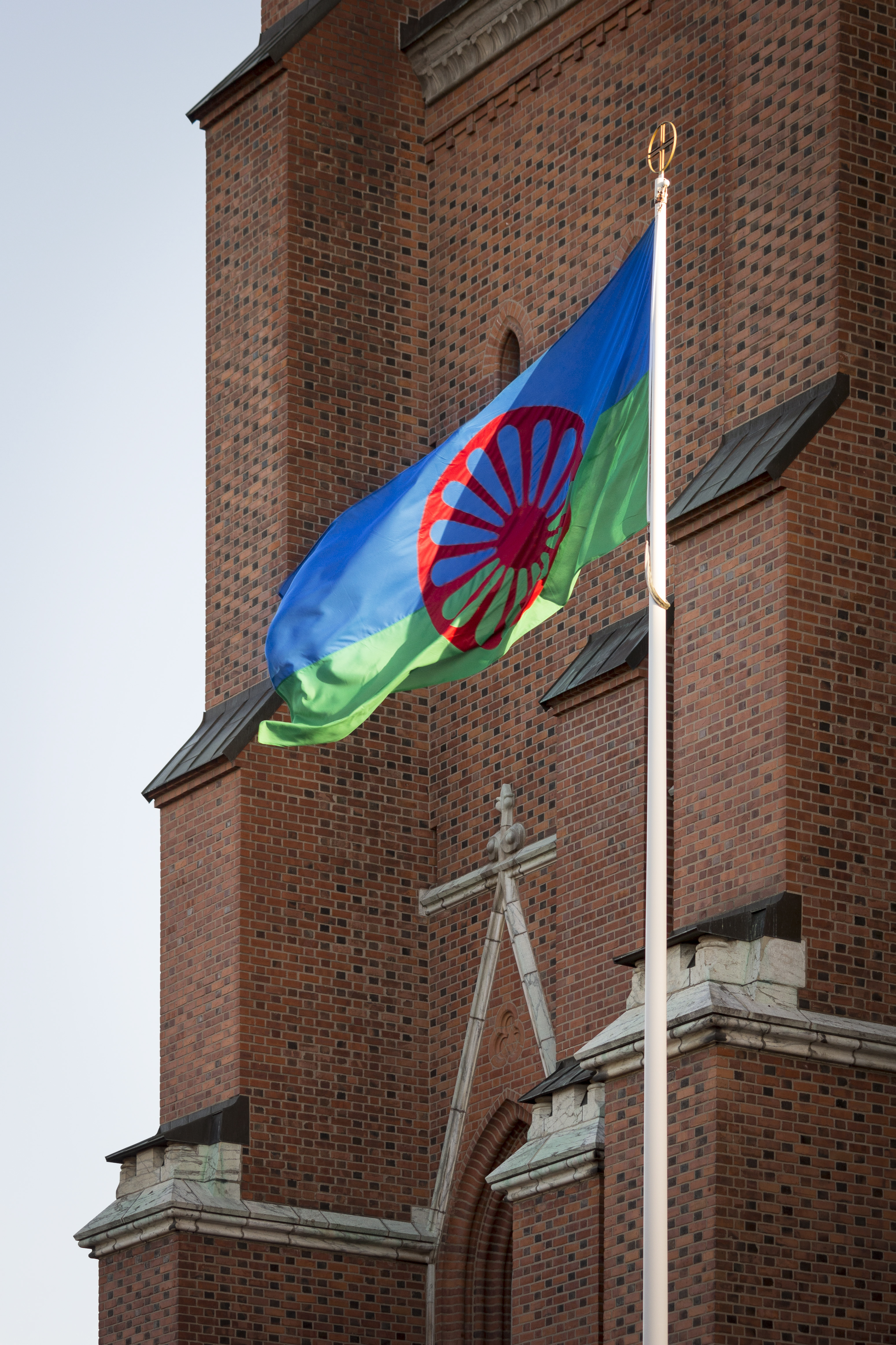 En flaggstång med den romska flaggan hissad står utanför Uppsala domkyrka.