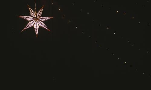 En adventsstjärna lyser i mörkret.