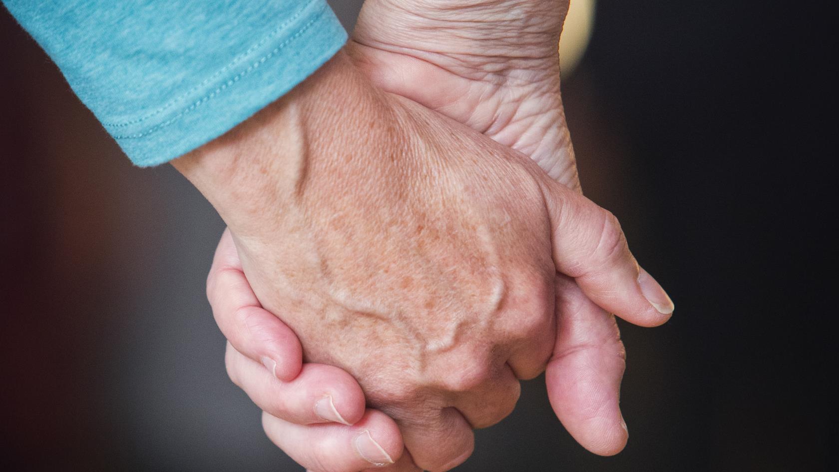 Två personer håller hand.