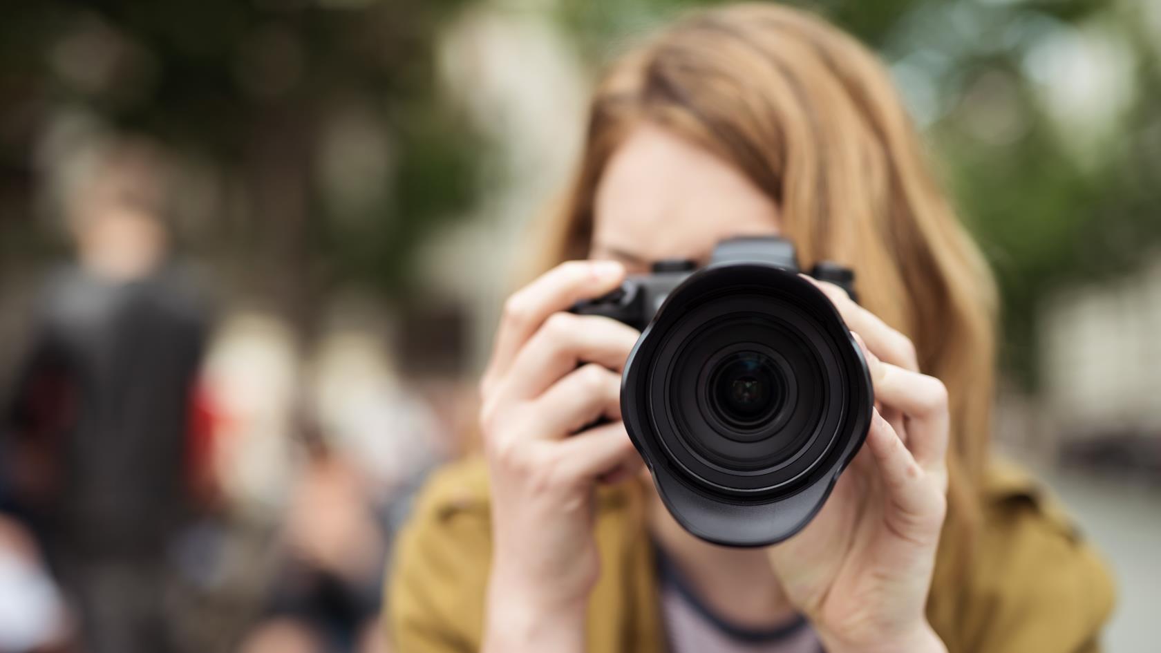 En kvinna fotograferar utomhus.