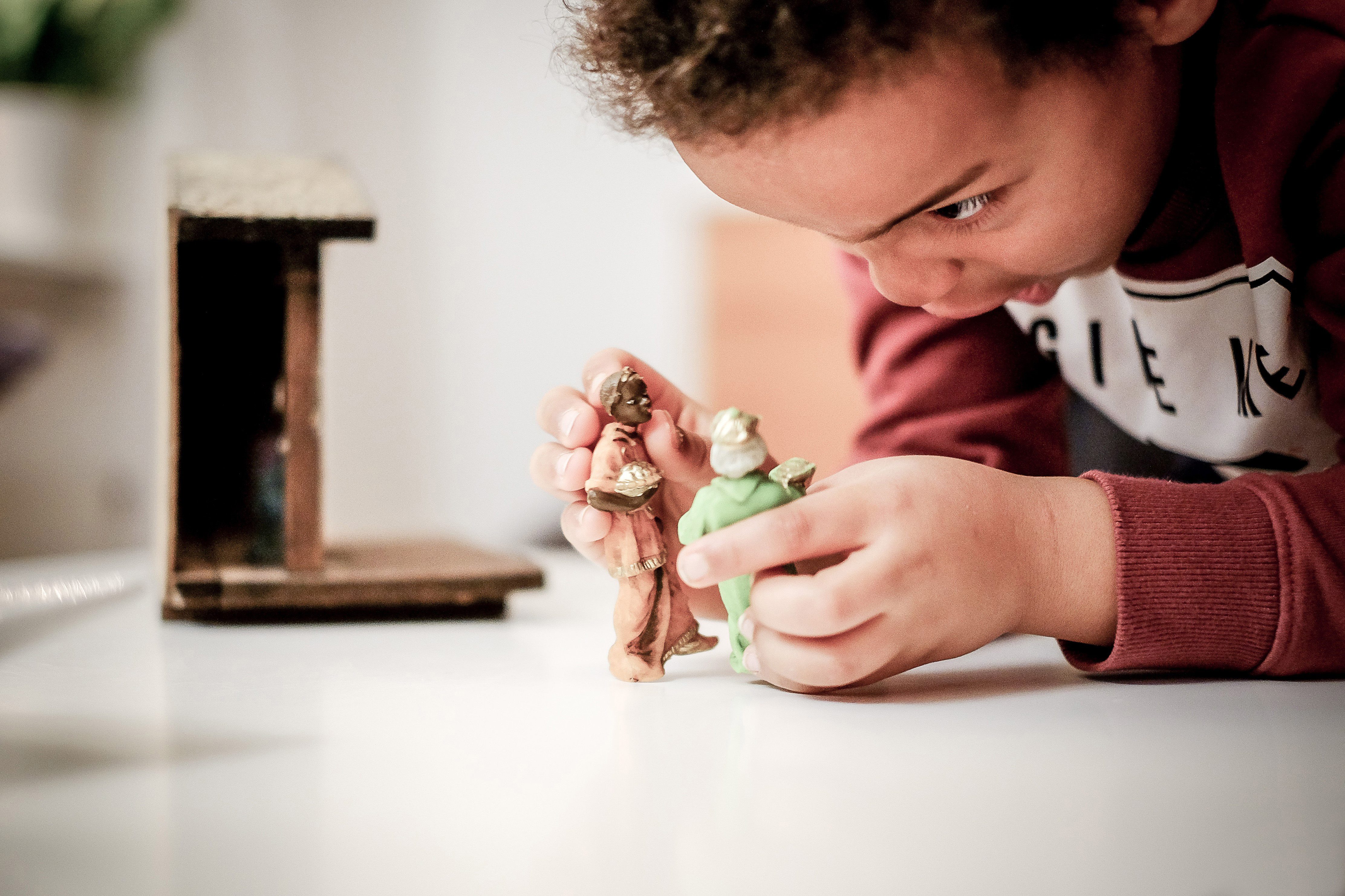 Ett barn leker med två små dockor.