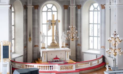 Ett stort kors och två statyer står på ett altare i en kyrka.