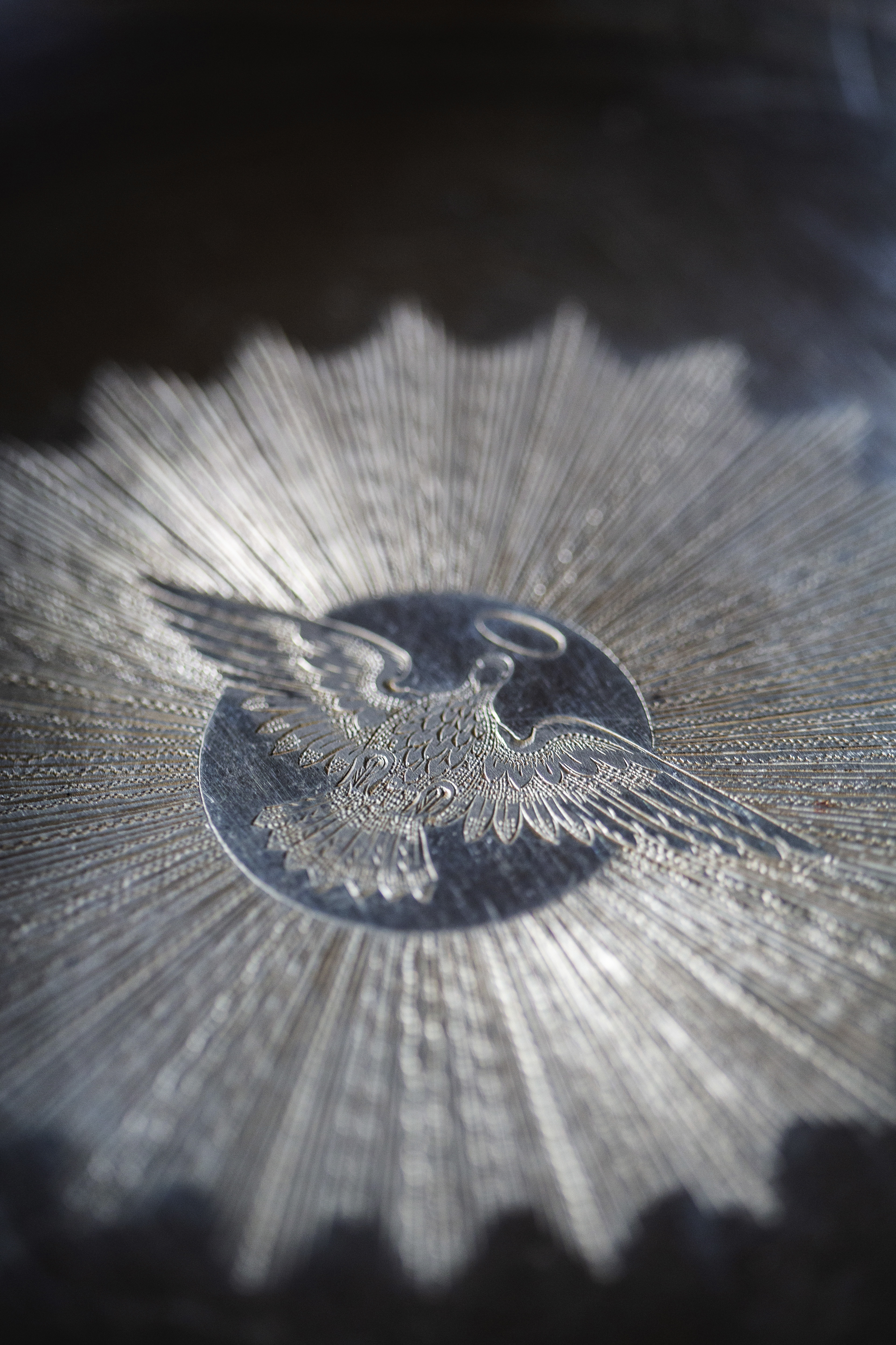 Gravering av en duva i silver.