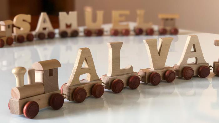 Två leksakståg med bokstäver på vagnarna som bildar namnen Samuel och Alva.