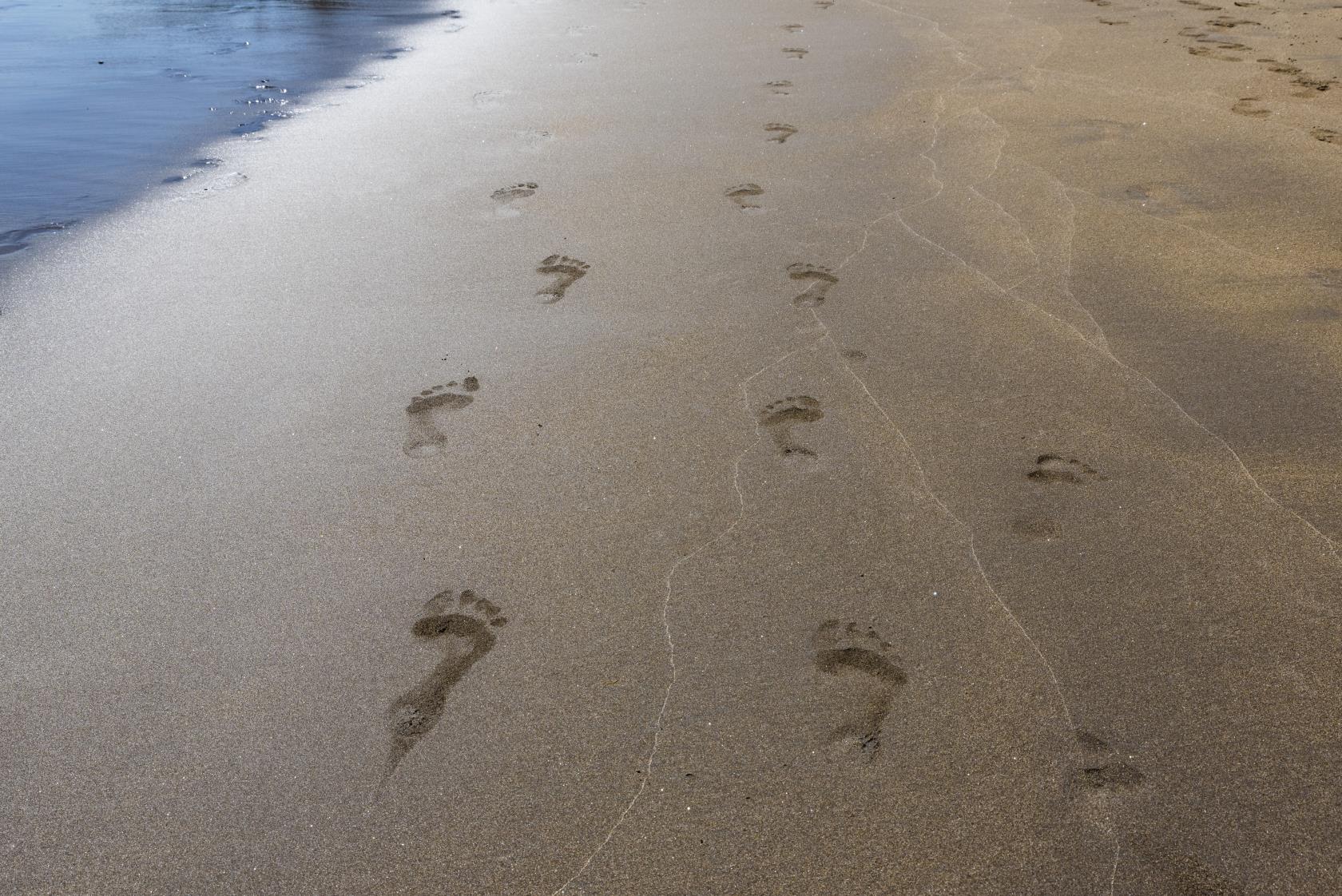 Fotspår i blöt sand.