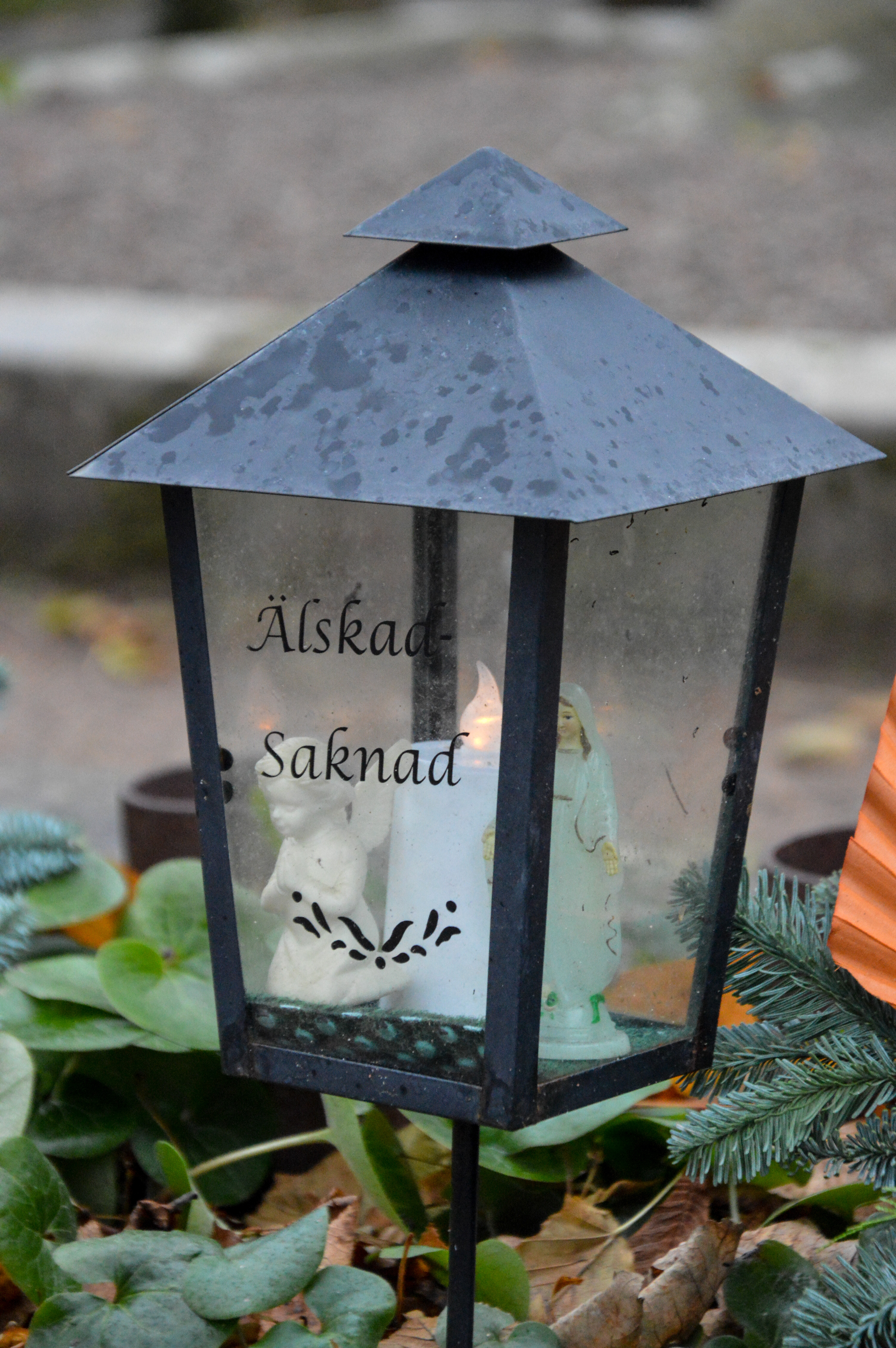 En gravlykta med texten Älskad Saknad.