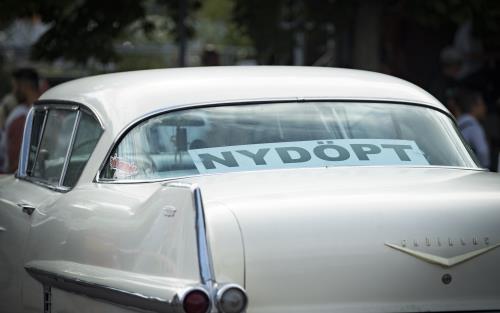 En skylt i bakrutan av en bil med texten Nydöpt.
