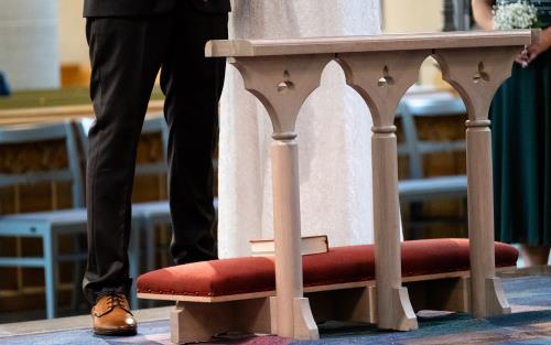 Ett brudpar står framför altaret.