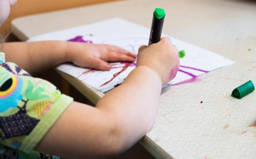 Ett barn sitter och ritar.