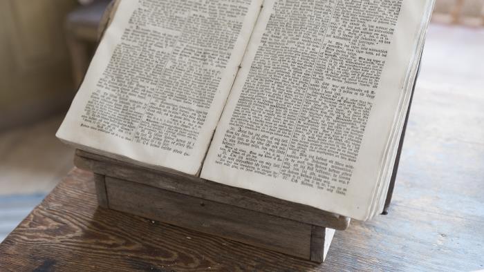 En gammal bibel ligger uppslagen på ett bord.