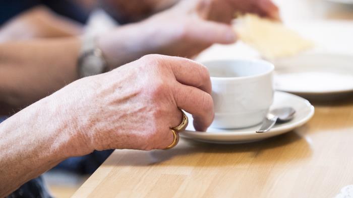 Någon lyfter upp en kaffekopp.