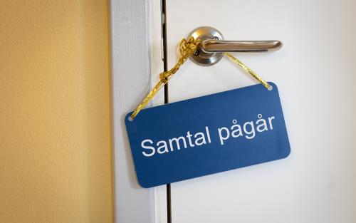 På ett handtag hänger en skylt med texten Samtal pågår.