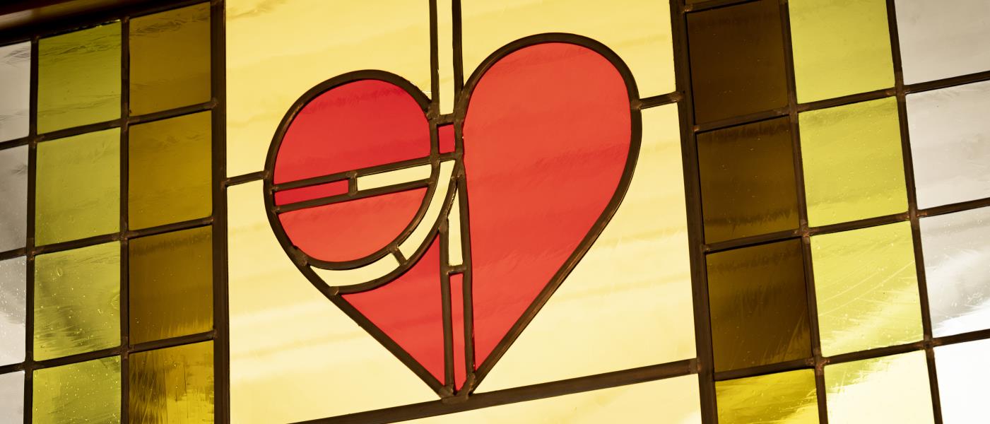 Ett blyinfattat färgat glasfönster med ett rött hjärta.