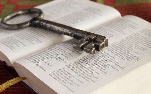 En gammal nyckel ligger på en uppslagen bibel.