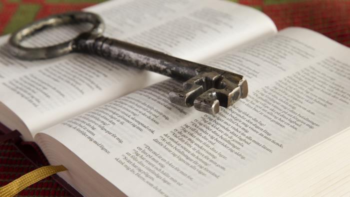 En gammal nyckel ligger på en uppslagen bibel.